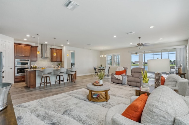 19183 Coastal Shore Ter, Land O Lakes, FL 34638 - living room with healthy amount of natural light, recessed lighting, ceiling fan, baseboards, and light wood-style flooring