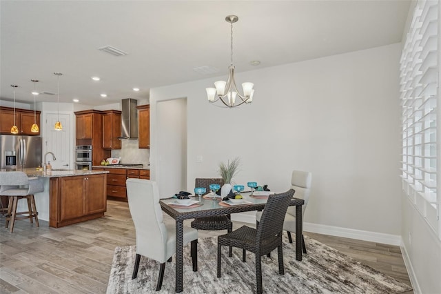 19183 Coastal Shore Ter, Land O Lakes, FL 34638 - dining room featuring light wood-style floors, a chandelier, baseboards, and recessed lighting
