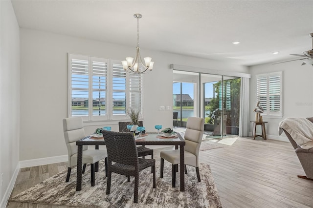 19183 Coastal Shore Ter, Land O Lakes, FL 34638 - dining area with a chandelier, wood finished floors, baseboards, recessed lighting, and a water view
