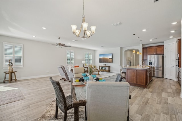 19183 Coastal Shore Ter, Land O Lakes, FL 34638 - dining room featuring a chandelier, arched walkways, a ceiling fan, light wood-type flooring, and recessed lighting
