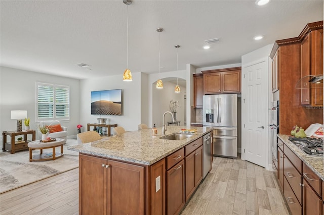 19183 Coastal Shore Ter, Land O Lakes, FL 34638 - kitchen featuring a sink, appliances with stainless steel finishes, arched walkways, light wood finished floors, and recessed lighting