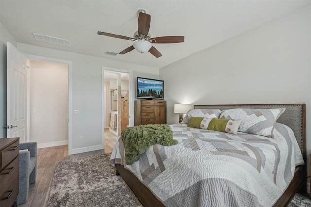 19183 Coastal Shore Ter, Land O Lakes, FL 34638 - bedroom featuring wood finished floors, baseboards, a ceiling fan, and connected bathroom