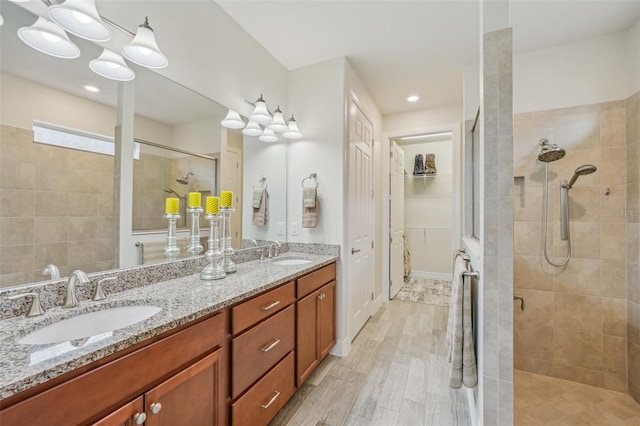 19183 Coastal Shore Ter, Land O Lakes, FL 34638 - full bath with a tile shower, double vanity, and wood finished floors