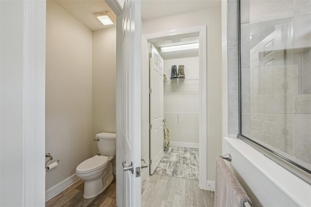 19183 Coastal Shore Ter, Land O Lakes, FL 34638 - full bathroom featuring toilet, wood finished floors, a spacious closet, and baseboards