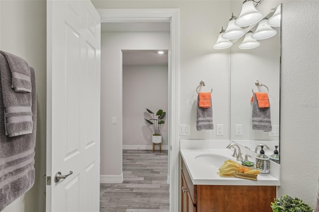 19183 Coastal Shore Ter, Land O Lakes, FL 34638 - bathroom with vanity, wood finished floors, a chandelier, and baseboards