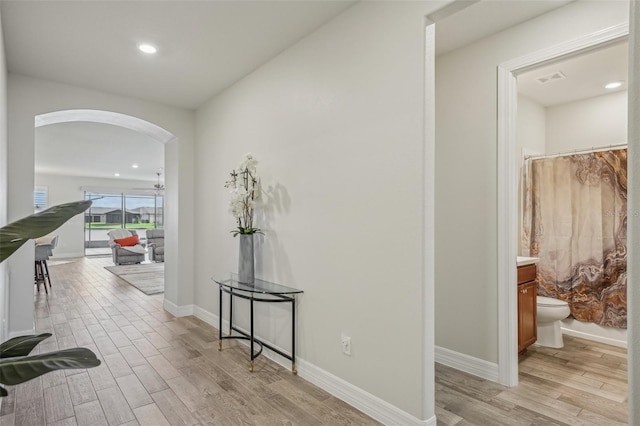 19183 Coastal Shore Ter, Land O Lakes, FL 34638 - hall with arched walkways, light wood-style flooring, baseboards, and recessed lighting