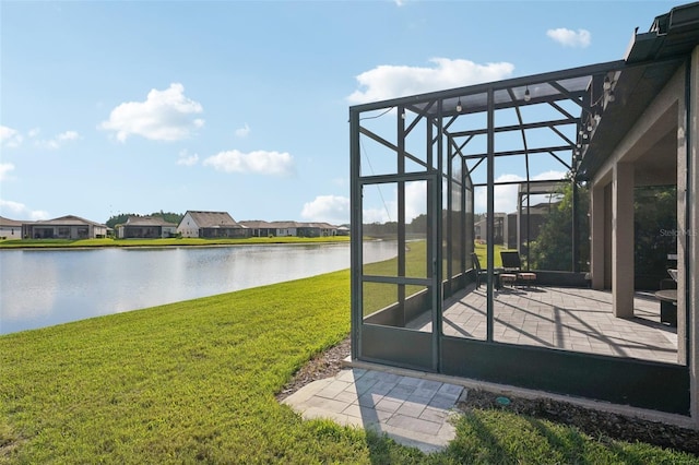19183 Coastal Shore Ter, Land O Lakes, FL 34638 - view of grassy yard with a water view, a patio area, glass enclosure, and a residential view
