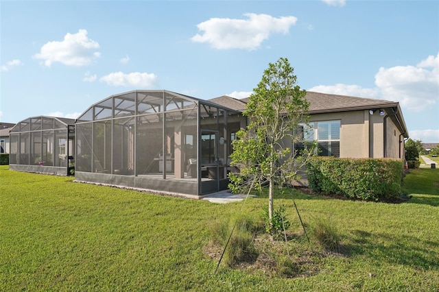 19183 Coastal Shore Ter, Land O Lakes, FL 34638 - back of house featuring a lawn, stucco siding, and glass enclosure