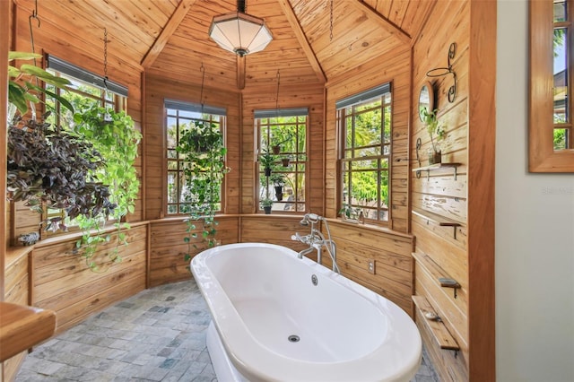 3112 W Wallcraft Ave, Tampa, FL 33611 - bathroom with wood walls, healthy amount of natural light, vaulted ceiling, a freestanding tub, and wood ceiling