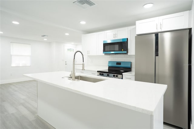 5510 12th St, Zephyrhills, FL 33542 - kitchen featuring stainless steel appliances, a sink, light wood-type flooring, white cabinets, and recessed lighting