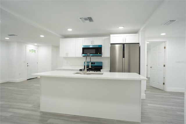 5510 12th St, Zephyrhills, FL 33542 - kitchen featuring stainless steel appliances, baseboards, light wood-style flooring, white cabinetry, and recessed lighting