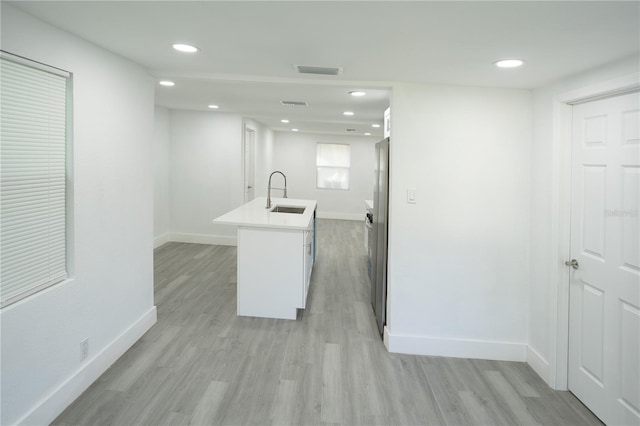 5510 12th St, Zephyrhills, FL 33542 - kitchen with a sink, baseboards, light wood-style floors, recessed lighting, and an island with sink