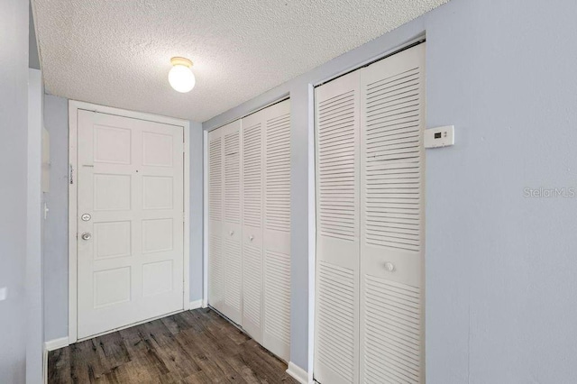 6324 Newtown Cir Unit 24B1, Tampa, FL 33615 - corridor with dark wood finished floors, a textured ceiling, and baseboards
