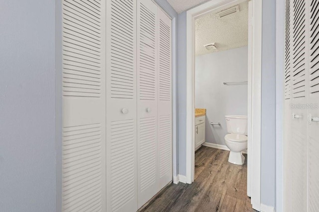 6324 Newtown Cir Unit 24B1, Tampa, FL 33615 - bathroom featuring a closet, a textured ceiling, toilet, wood finished floors, and baseboards