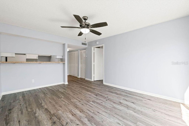 6324 Newtown Cir Unit 24B1, Tampa, FL 33615 - unfurnished living room with wood finished floors, ceiling fan, baseboards, and a textured ceiling