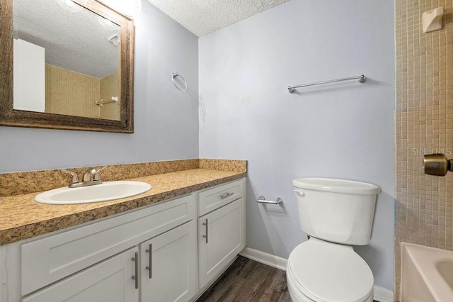 6324 Newtown Cir Unit 24B1, Tampa, FL 33615 - full bathroom with vanity, a textured ceiling, toilet, wood finished floors, and baseboards