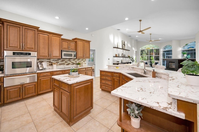 4962 Turtle Creek Trl, Oldsmar, FL 34677 - kitchen featuring a spacious island, stainless steel appliances, a warming drawer, a sink, and a ceiling fan