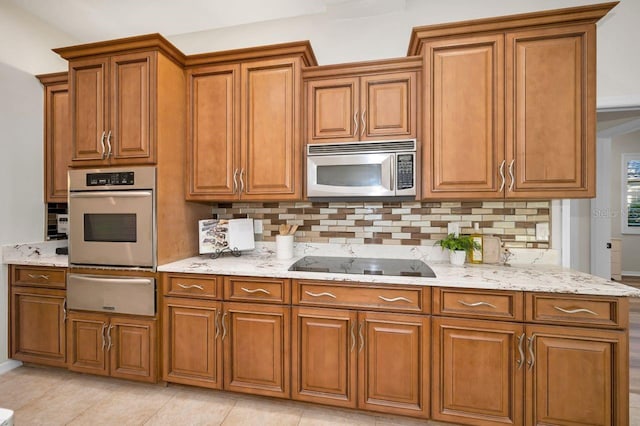 4962 Turtle Creek Trl, Oldsmar, FL 34677 - kitchen featuring appliances with stainless steel finishes, a warming drawer, brown cabinetry, and decorative backsplash