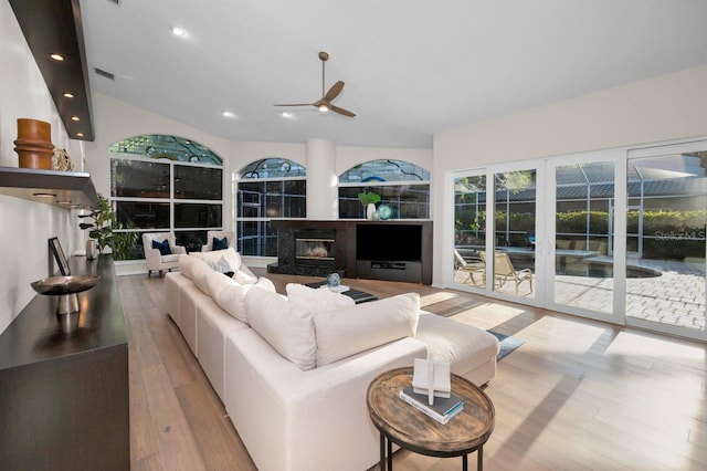 4962 Turtle Creek Trl, Oldsmar, FL 34677 - living area featuring ceiling fan, wood finished floors, a glass covered fireplace, lofted ceiling, and recessed lighting