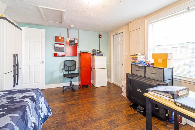 9020 Gray Fox Ln, Port Richey, FL 34668 - bedroom featuring freestanding refrigerator, wood finished floors, a textured ceiling, baseboards, and fridge