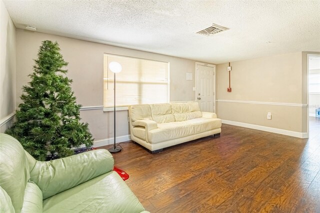 9020 Gray Fox Ln, Port Richey, FL 34668 - living room featuring wood finished floors, a textured ceiling, plenty of natural light, and baseboards