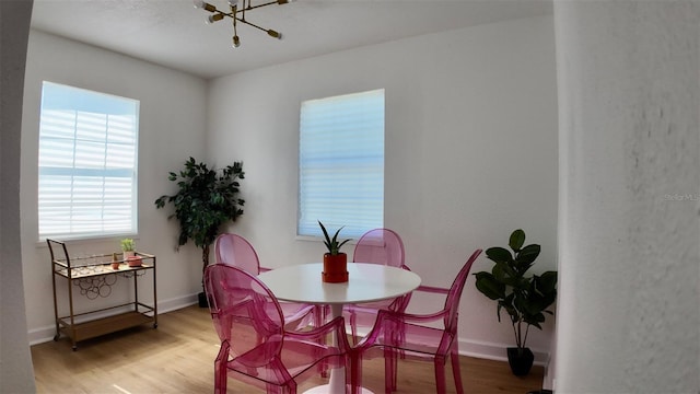 2219 Thrace St, Tampa, FL 33605 - dining area featuring light wood finished floors, a chandelier, and baseboards