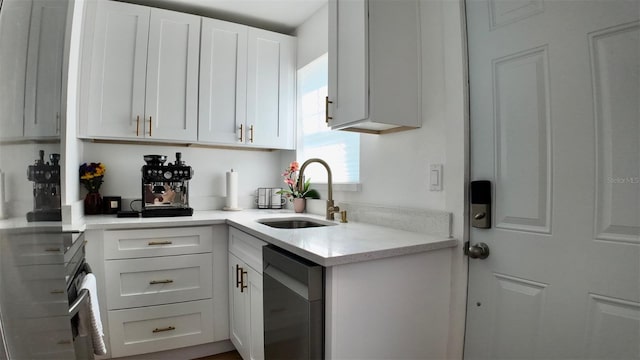 2219 Thrace St, Tampa, FL 33605 - kitchen featuring stainless steel appliances, a sink, light countertops, and white cabinets