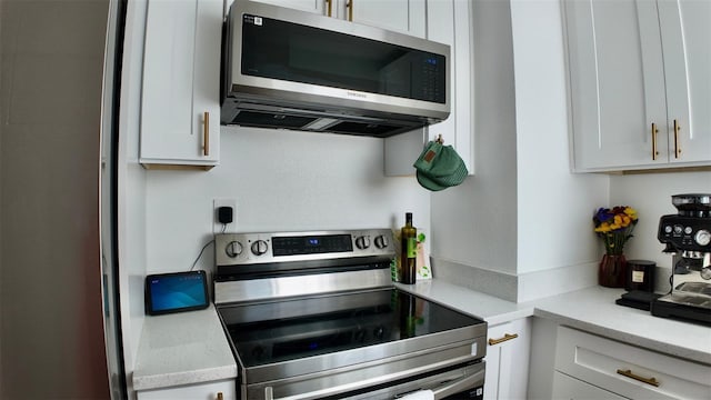 2219 Thrace St, Tampa, FL 33605 - kitchen featuring stainless steel appliances, white cabinetry, and light stone countertops
