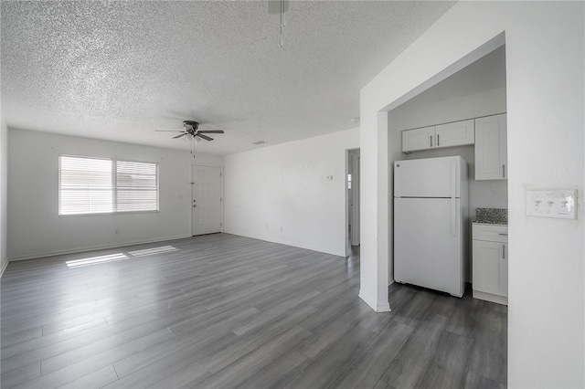 725 2nd Ave NE, Largo, FL 33770 - unfurnished living room with ceiling fan, a textured ceiling, dark wood-style flooring, and baseboards