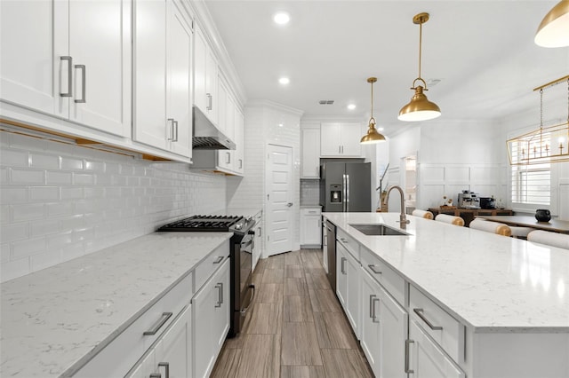 4345 Cadence Loop, Land O Lakes, FL 34638 - kitchen with a sink, appliances with stainless steel finishes, under cabinet range hood, white cabinets, and tasteful backsplash