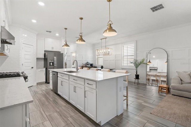 4345 Cadence Loop, Land O Lakes, FL 34638 - kitchen with wall chimney exhaust hood, a sink, a decorative wall, backsplash, and appliances with stainless steel finishes