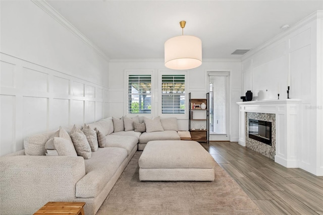 4345 Cadence Loop, Land O Lakes, FL 34638 - living room with a decorative wall, a high end fireplace, wood finished floors, and crown molding