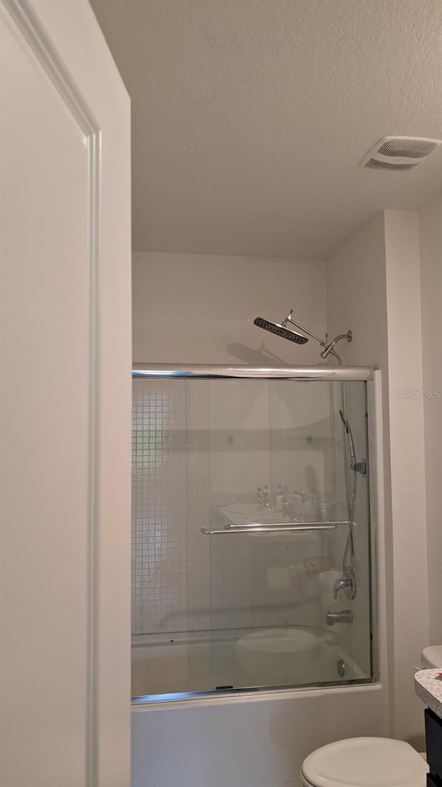 3446 Suncoast Plains Dr, Odessa, FL 33556 - bathroom with toilet, bath / shower combo with glass door, vanity, and a textured ceiling