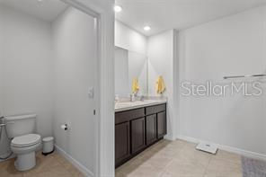 3446 Suncoast Plains Dr, Odessa, FL 33556 - bathroom featuring toilet, vanity, baseboards, recessed lighting, and tile patterned floors