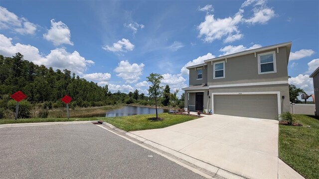 3446 Suncoast Plains Dr, Odessa, FL 33556 - traditional home with stucco siding, concrete driveway, a water view, a garage, and a front lawn