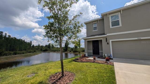 3446 Suncoast Plains Dr, Odessa, FL 33556 - view of front of property with stucco siding, a water view, a front yard, driveway, and a garage
