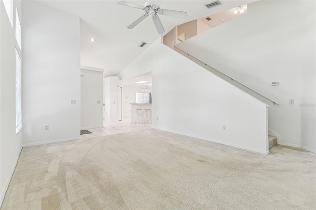 1624 Lullwater Ln, Lutz, FL 33549 - unfurnished living room featuring light carpet, a ceiling fan, stairs, a towering ceiling, and baseboards