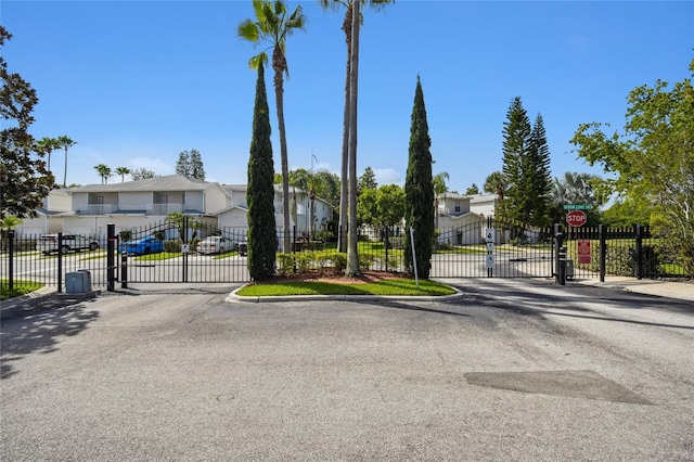 1624 Lullwater Ln, Lutz, FL 33549 - view of asphalt street with a gate, a gated entry, traffic signs, and curbs