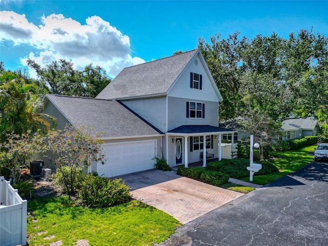 2311 64th Street Ct W, Bradenton, FL 34209 - view of front of house with decorative driveway, an attached garage, a shingled roof, a front yard, and a porch