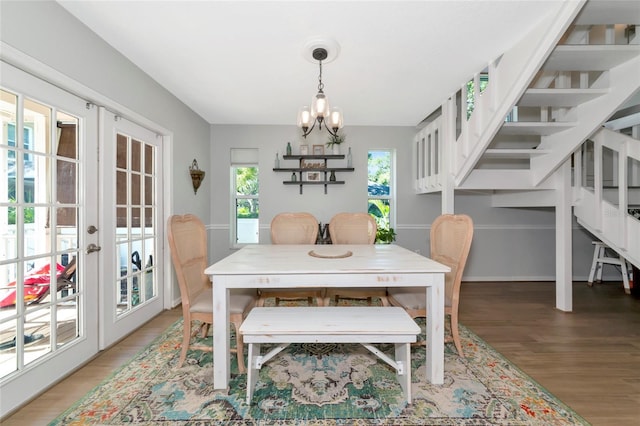 2311 64th Street Ct W, Bradenton, FL 34209 - dining room with light wood-style floors, french doors, a chandelier, and stairs