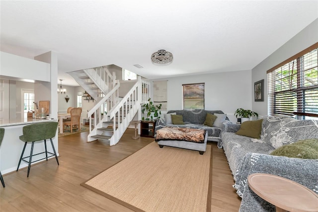 2311 64th Street Ct W, Bradenton, FL 34209 - living area featuring stairs, light wood-style flooring, healthy amount of natural light, and a chandelier