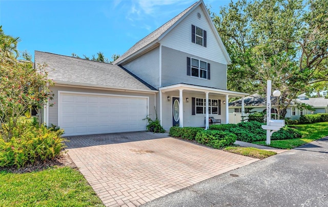 2311 64th Street Ct W, Bradenton, FL 34209 - traditional-style home with decorative driveway, a porch, an attached garage, and a shingled roof