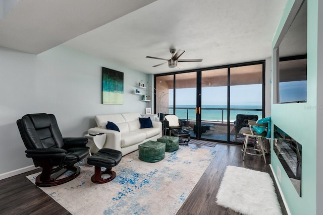 1310 Gulf Blvd Unit 6C, Clearwater Beach, FL 33767 - living room with expansive windows, ceiling fan, wood finished floors, a water view, and baseboards