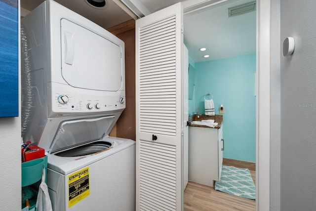 1310 Gulf Blvd Unit 6C, Clearwater Beach, FL 33767 - laundry room with estacked washer and dryer and light wood-style flooring