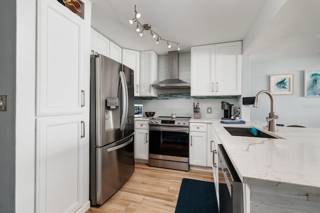 1310 Gulf Blvd Unit 6C, Clearwater Beach, FL 33767 - kitchen featuring appliances with stainless steel finishes, wall chimney exhaust hood, a sink, and white cabinetry