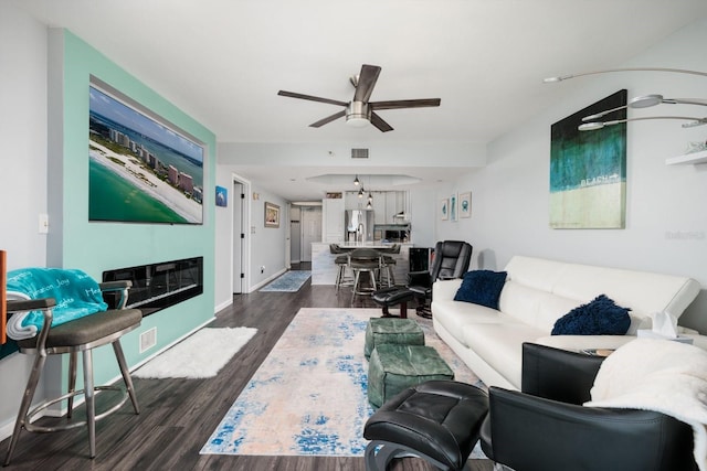 1310 Gulf Blvd Unit 6C, Clearwater Beach, FL 33767 - living area with ceiling fan, dark wood-type flooring, baseboards, and a glass covered fireplace