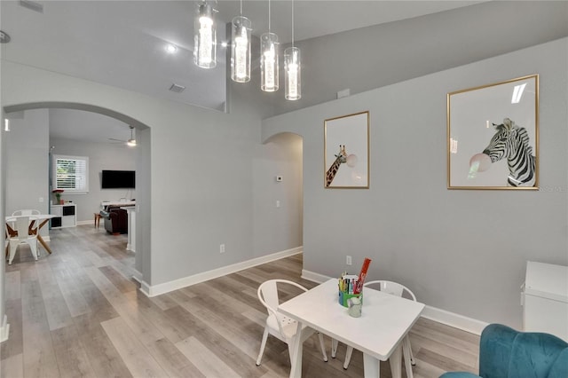 16367 Ashington Park Dr, Tampa, FL 33647 - dining area with arched walkways, ceiling fan, light wood finished floors, and baseboards