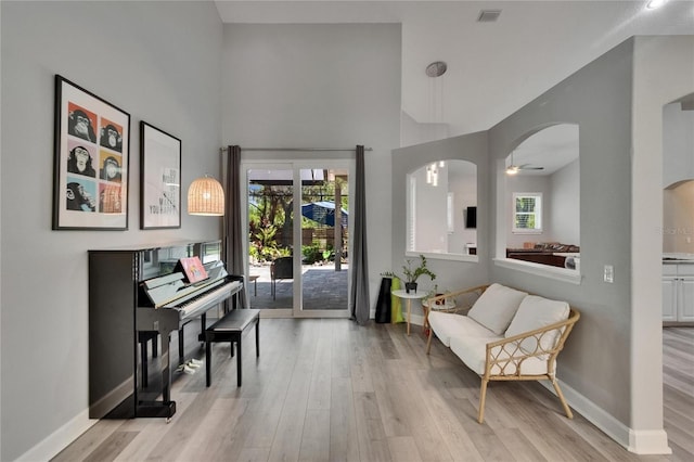 16367 Ashington Park Dr, Tampa, FL 33647 - living area with arched walkways, light wood-style flooring, baseboards, and a towering ceiling