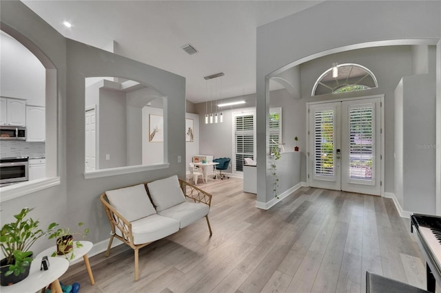 16367 Ashington Park Dr, Tampa, FL 33647 - entryway featuring french doors, baseboards, light wood-style floors, and arched walkways