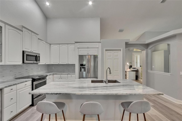 16367 Ashington Park Dr, Tampa, FL 33647 - kitchen featuring stainless steel appliances, a sink, a breakfast bar, light wood-type flooring, and recessed lighting